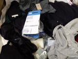 a pile of clothes that is on a bed
