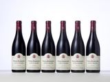 six bottles of red wine lined up in a row