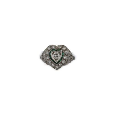une image d'une bague en forme de cœur sertie de diamants et d'émeraudes sur fond blanc