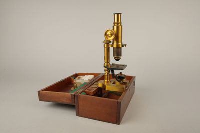 une boîte en bois sur laquelle est posé un microscope