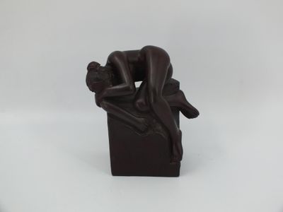 statue représentant un homme assis sur une caisse, la tête posée sur le dos d'une femme