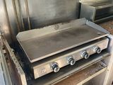 stainless steel counter top with three burners and a griddle on it