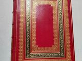 an old red book with gold trimming and a gold border