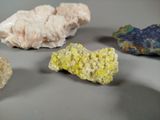 several different colored rocks on a table with a white background