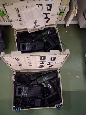 deux cartons ouverts contenant du matériel électronique, posés par terre