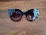 un gros plan sur une paire de lunettes de soleil posée sur un parquet