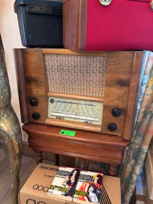 une pile de valises posée sur une table, à côté d'une vieille radio