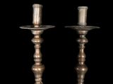 pair of antique brass candlesticks on a black background