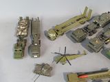 a lot of toy army vehicles and a helicopter on a table
