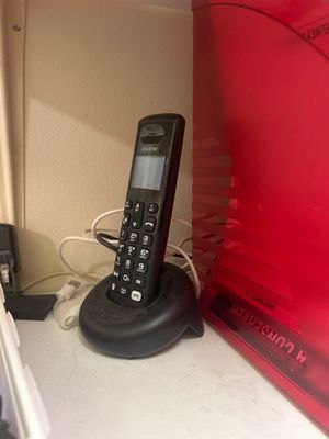 un téléphone posé sur un support à côté d'un micro-ondes