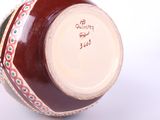 a close up of a vase on a white surface