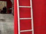 une échelle appuyée contre un mur rouge dans un garage