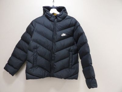 the jacket is hanging on a hanger on the wall