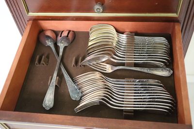 many forks and spoons in a wooden box