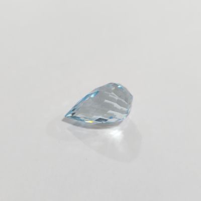 un gros plan d'un diamant topaze bleue sur une surface blanche