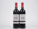 deux bouteilles de vin rouge posées l'une à côté de l'autre sur une surface blanche