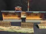 a small wooden building with a fence and a bird house