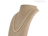 pearl necklace on a mannequin display with a white background