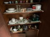 a wooden cabinet with many dishes and bowls on it