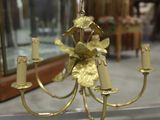 a gold chandelier with candles on it in a glass case
