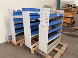 two blue and white shelvings stacked on pallets in a warehouse