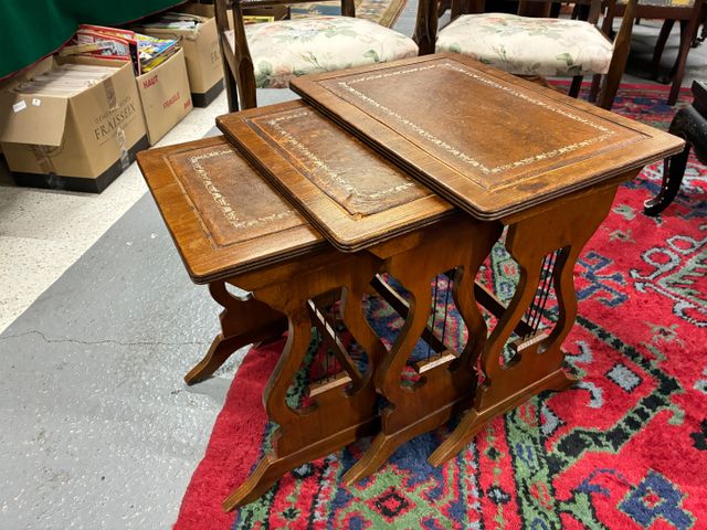 Suite de trois tables gigogne, pieds lyres, plateau gainé de cuir
