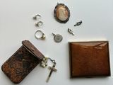 une petite boîte contenant une clé, une bague et d'autres objets, posée sur une surface blanche