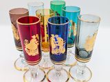 many different colored glasses with gold designs on them
