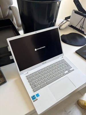 a laptop computer sitting on a desk next to a chair