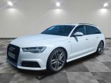 a white audi wagon parked in a large room with a checkered floor