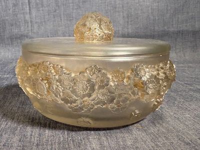 un saladier en verre muni d'un couvercle orné d'un motif floral
