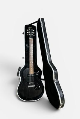 a black guitar and a black case on a white background