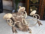 a statue of a dog on a table with a plant in the background