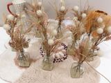 several vases of dried flowers are sitting on a table