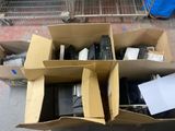 Des cartons contenant du matériel électronique sont empilés les uns sur les autres dans un entrepôt