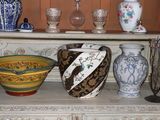 many vases and bowls on a shelf in a room