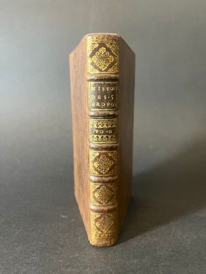 an old book sitting on top of a wooden book stand
