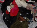 a pile of clothes that is on a bed