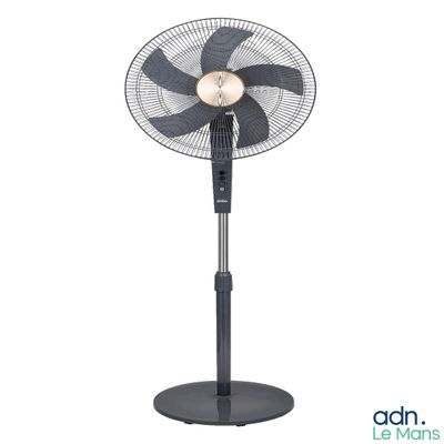 un ventilateur noir posé sur un support métallique, près d'un mur blanc