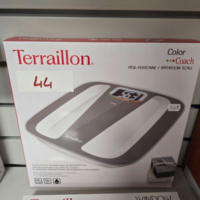 une boîte sur laquelle est posée une balance numérique, posée sur une étagère