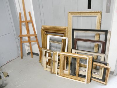 a lot of picture frames and a ladder in a room