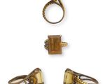 three gold rings and a ring with a square shaped stone