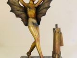 statue of a woman with wings and a suitcase on a marble base