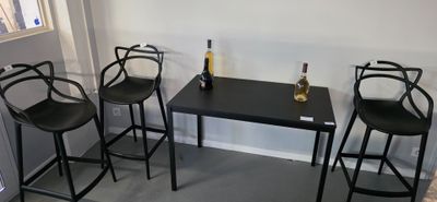 three chairs and a table with a bottle of wine on it