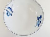 a white bowl with blue flowers on it on a table