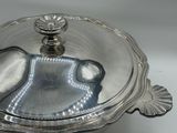 a silver plate with a lid on a white table