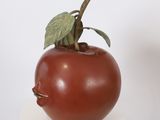 a sculpture of a tomato with a face on it