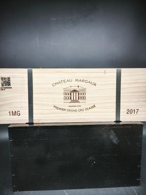 un gros plan d'une boîte en bois sur laquelle repose une bouteille de vin