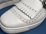 a close up of a pair of white shoes on a blue surface