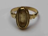 un gros plan d'une bague en or sertie d'une pierre